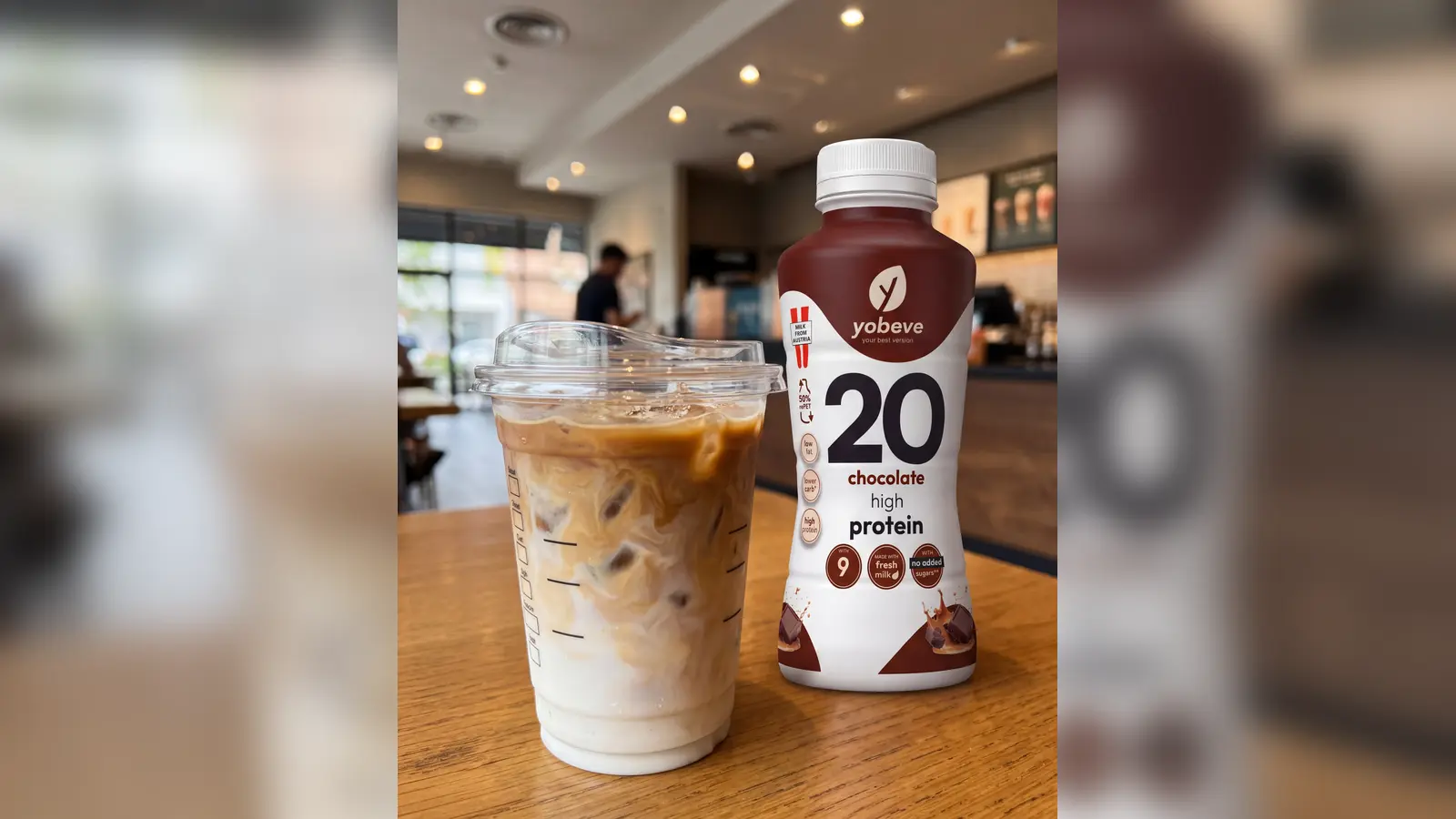 Chai protein drink pha sẵn cạnh cà phê sữa đá